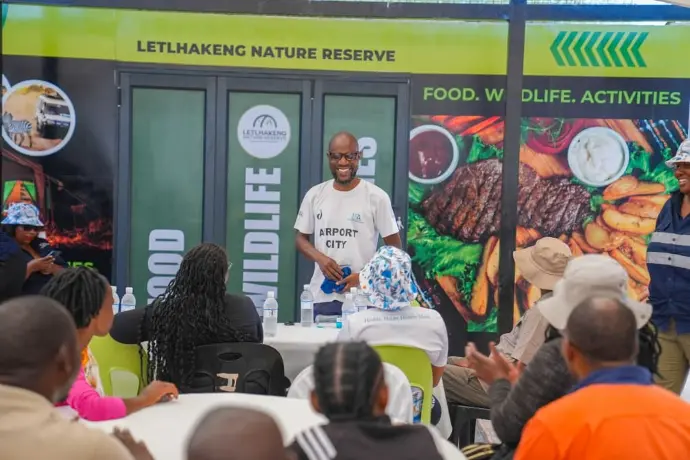 Guests seated at a Letlhakeng Nature Reserve event beside the food, wildlife and activities banner